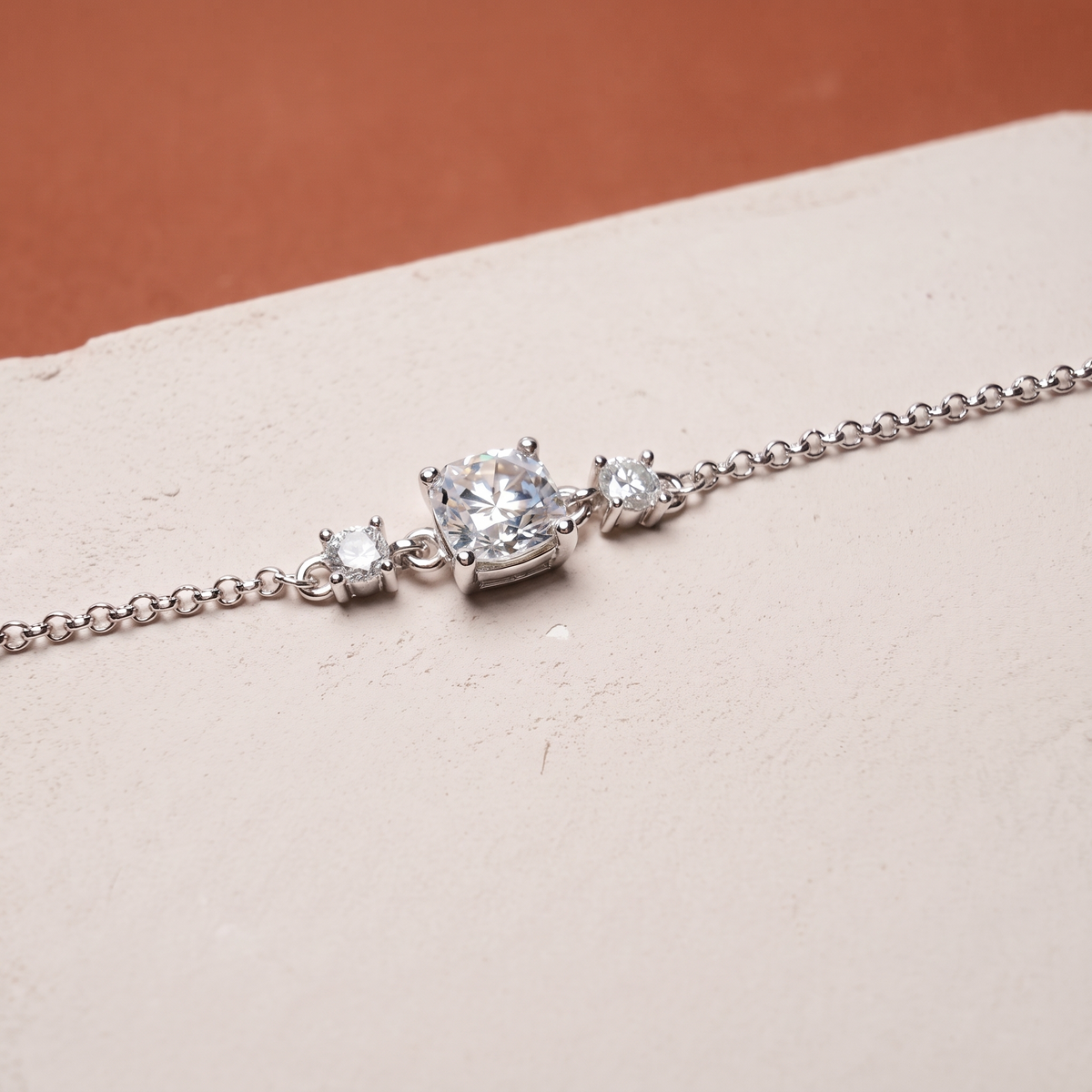 Moissanite solitaire bracelet on a plaster slab against terracotta