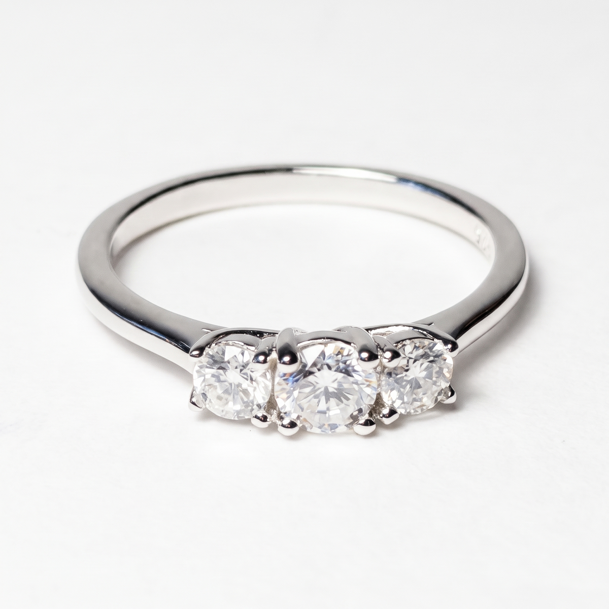 Three-stone moissanite ring, front view on white