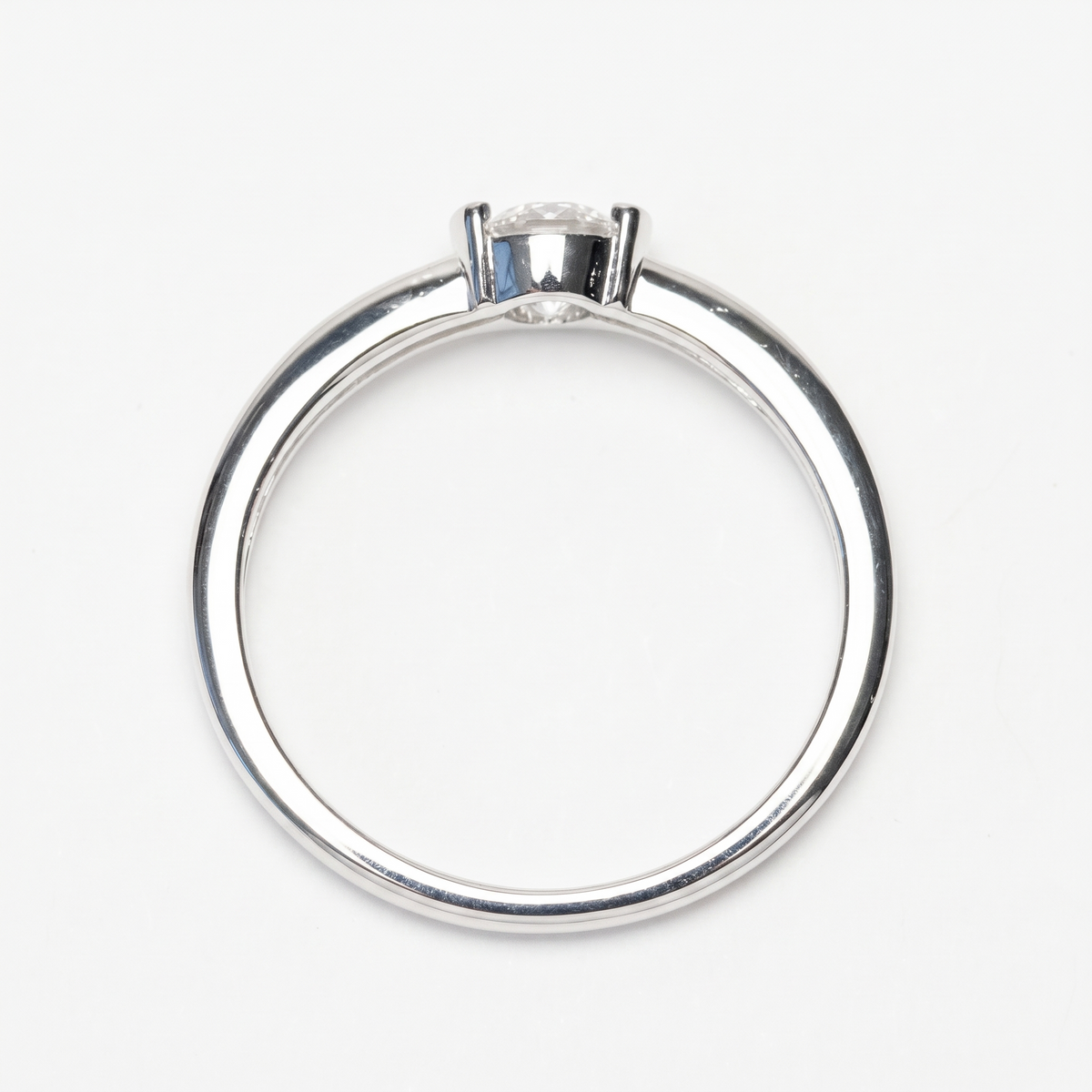 Half-bezel moissanite ring, front view on white